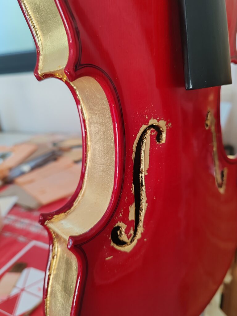 Violon doré à la feuille d'or sur les ouïes et le tour du violon ; partenariat entre Annie Gaudin, doreuse, et Benjamin Beugnies, luthier